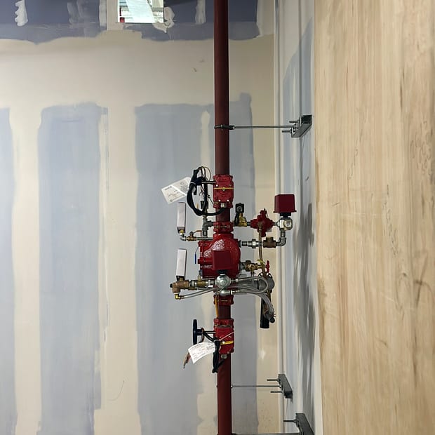 Sprinkler alarm valve set on a riser in a corridor under fit-out