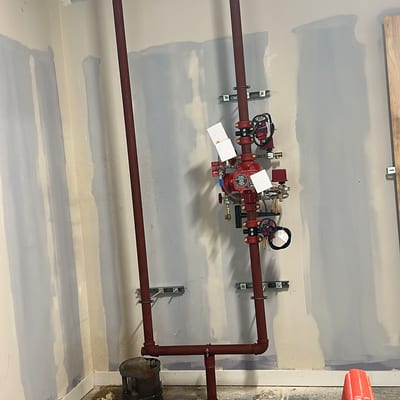 Sprinkler alarm valve set and riser on a wall in a room under fit-out