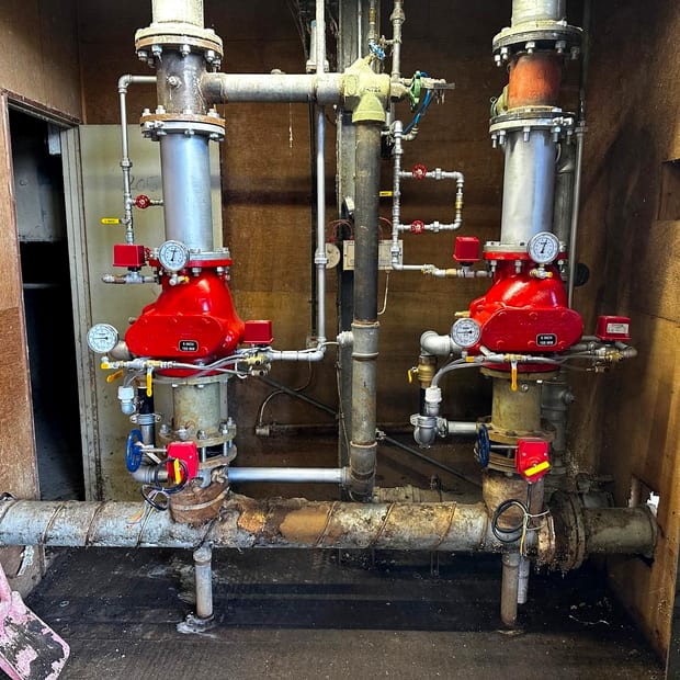 Two six inch dry pipe sprinkler valve sets with air maintenance trim and gauges in a plant room