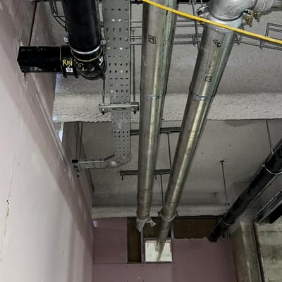 New grey dry riser pipework run through a service void, installed and awaiting completion