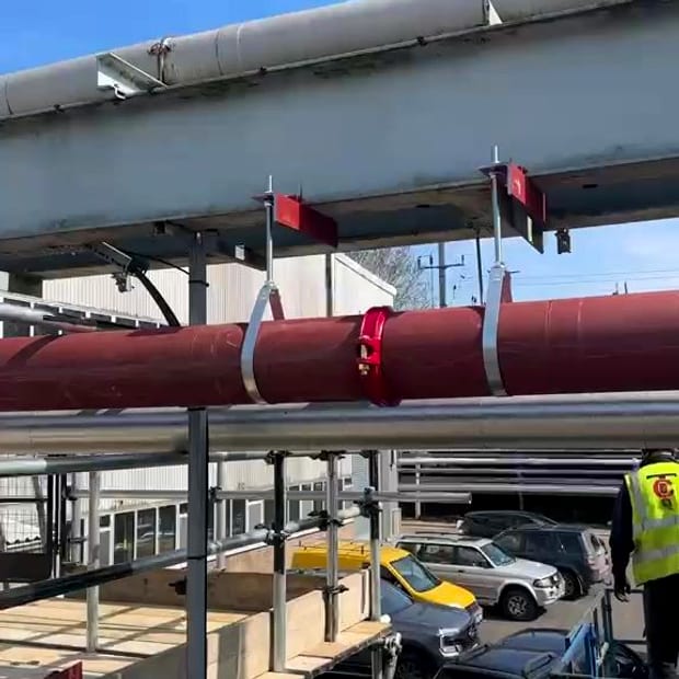 External sprinkler main carried on a support gantry
