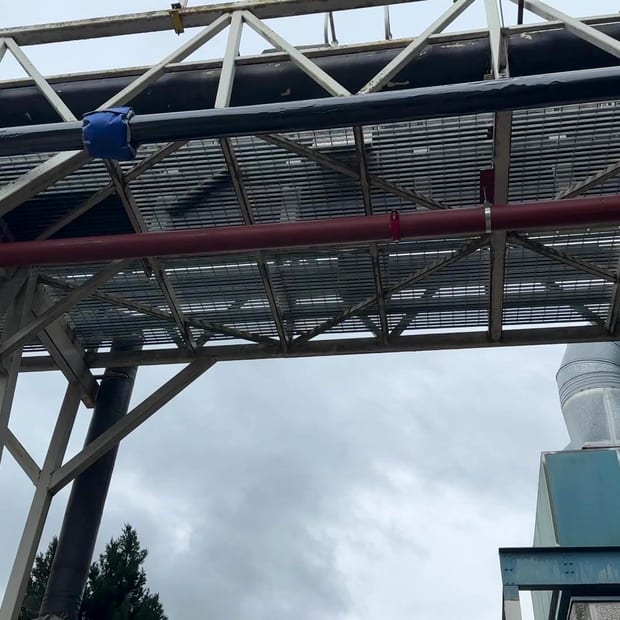 External pipe bridge carrying a main across a steel gantry