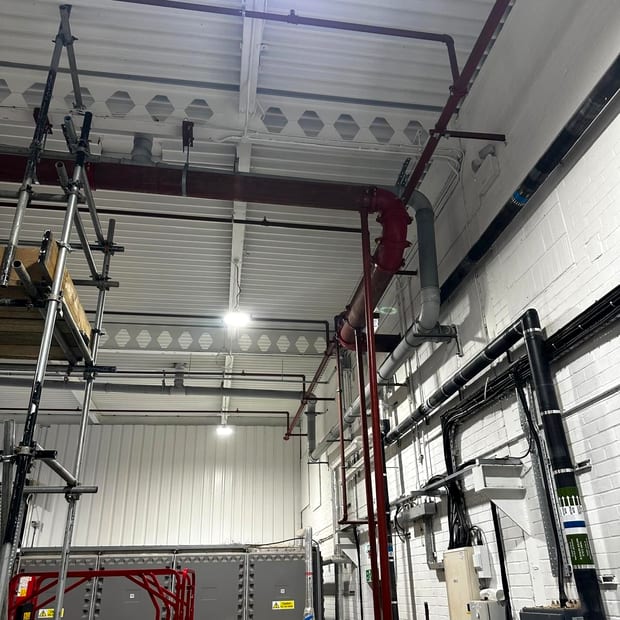 Sprinkler pipework routed above electrical panels