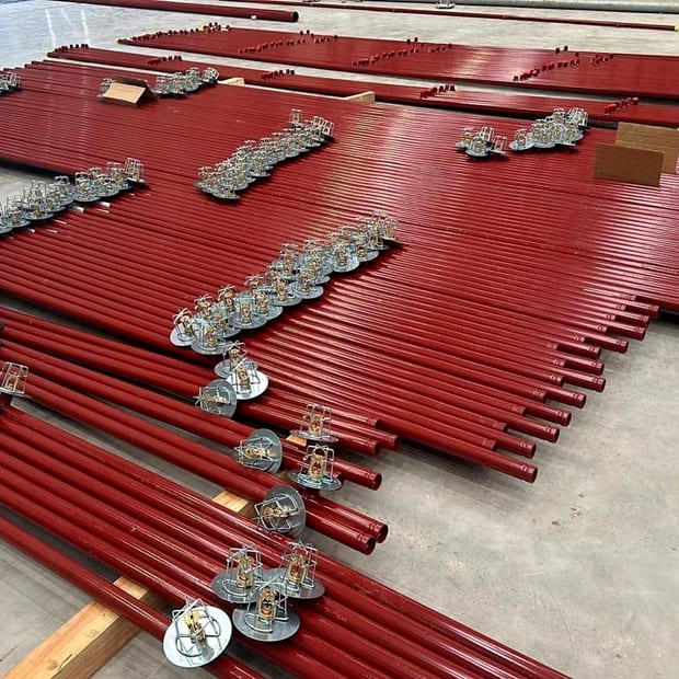 Prefabricated sprinkler pipework and brackets laid out ready to install