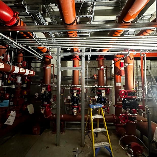 Valve assemblies and overhead mains in a plant room