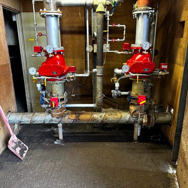 Two alarm valve sets and their gauges in a riser cupboard
