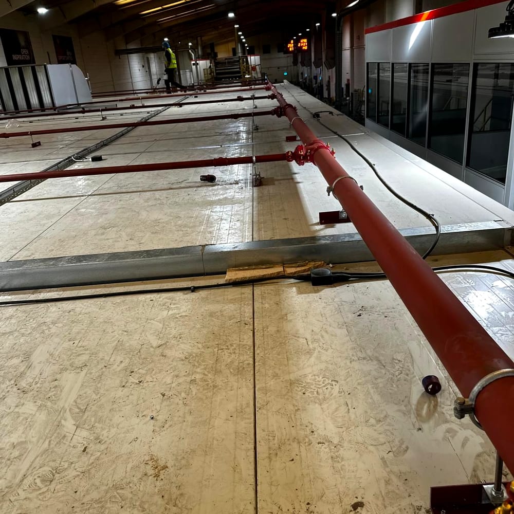 Sprinkler main being run out across a warehouse