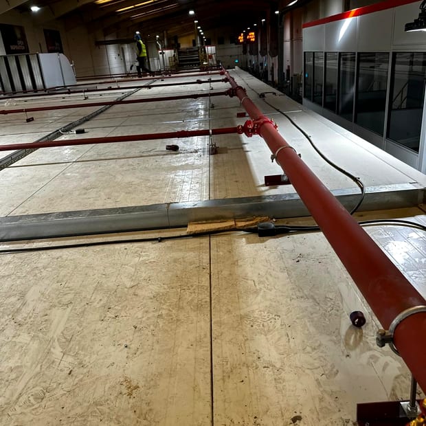 Sprinkler main being run out across a warehouse