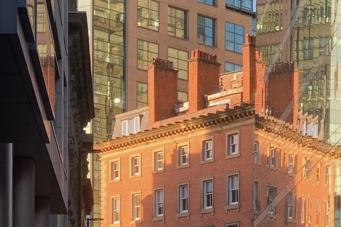 A period brick office building between modern glass towers