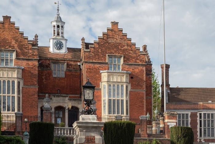 Red brick school buildings with a clock tower and stepped gables